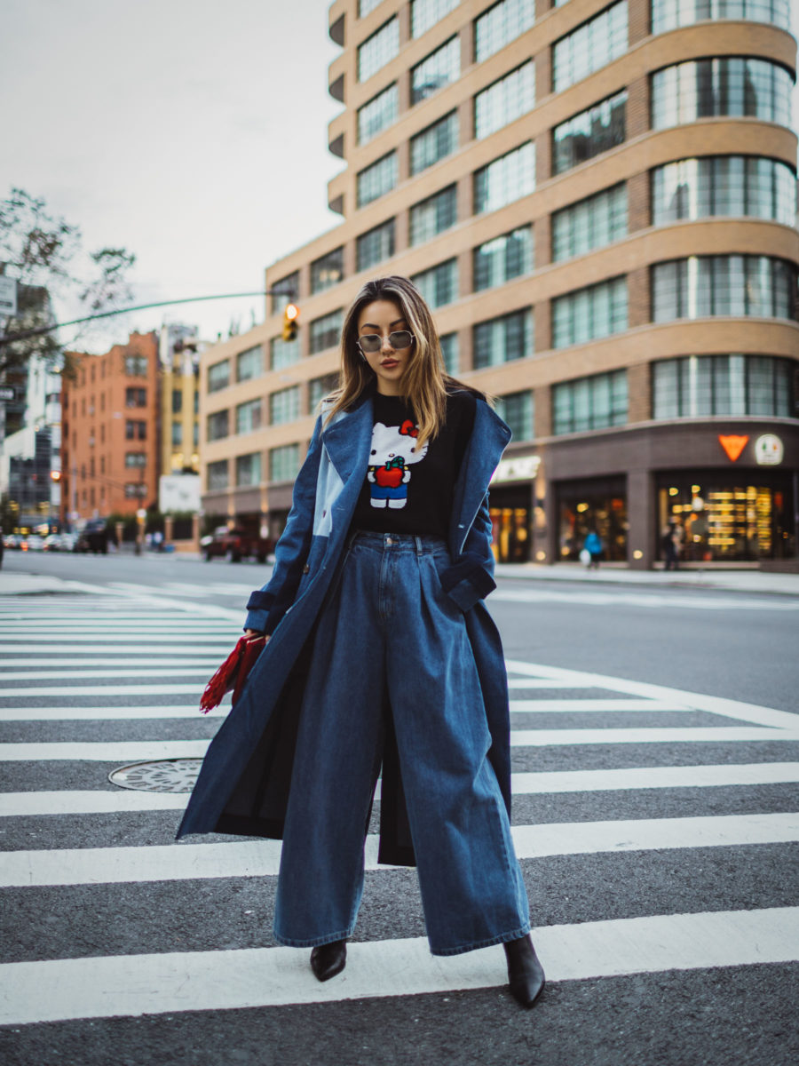 jessica wang wearing a blue trench coat, a hello kitty graphic tee, and wide leg jeans while sharing TikTok fashion trends // Jessica Wang - Notjessfashion.com