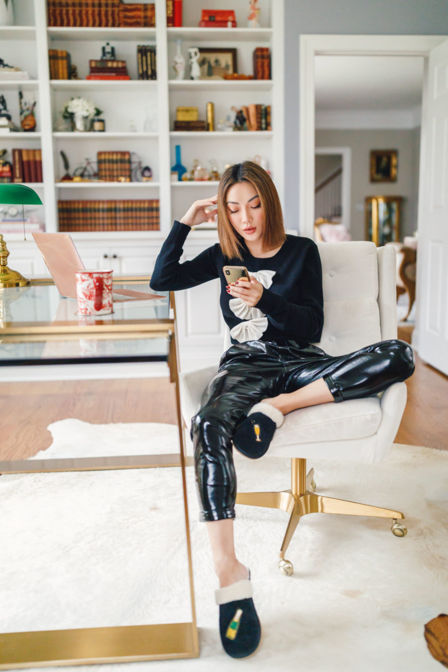 Jessica Wang wearing a black sweater and leather pants with shearling clogs while sharing holiday gifts for her for 2021 // Jessica Wang - Notjessfashion.com