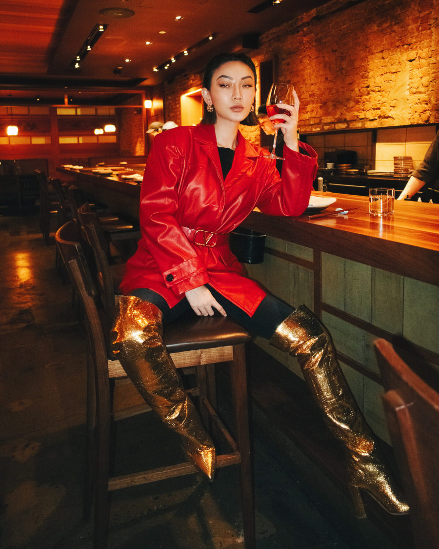 Jessica Wang wearing top fall shoe trends featuring a red leather jacket with black tights, and metallic gold over the knee boots // Jessica Wang - Notjessfashion.com