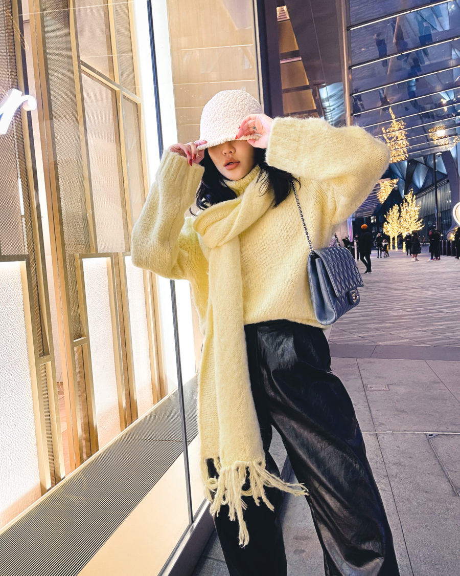 Jessica wang wearing a shearling bucket hat with an oversized scarf while sharing tips on how to layer // Jessica Wang - Notjessfashion.com